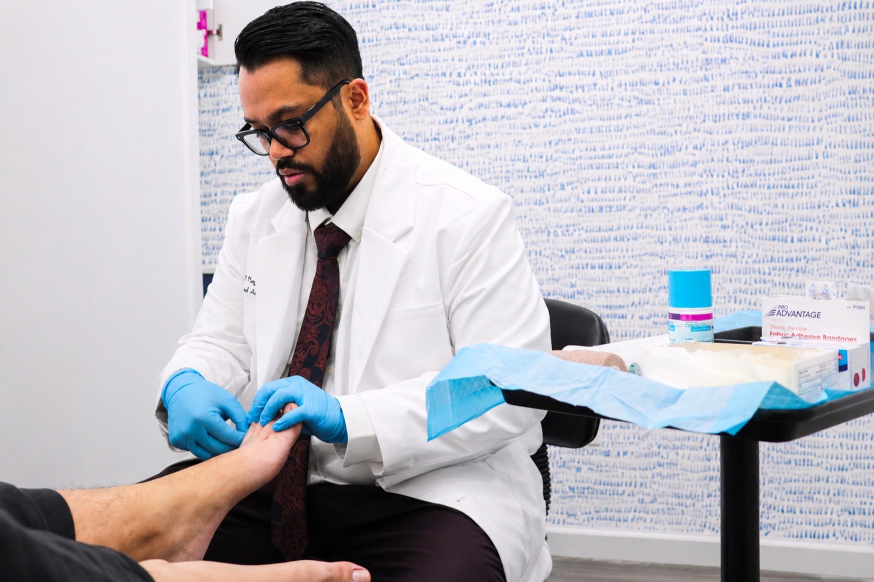 Dr. Nayeem examining a patient's foot at Mobile Podiatry NYC